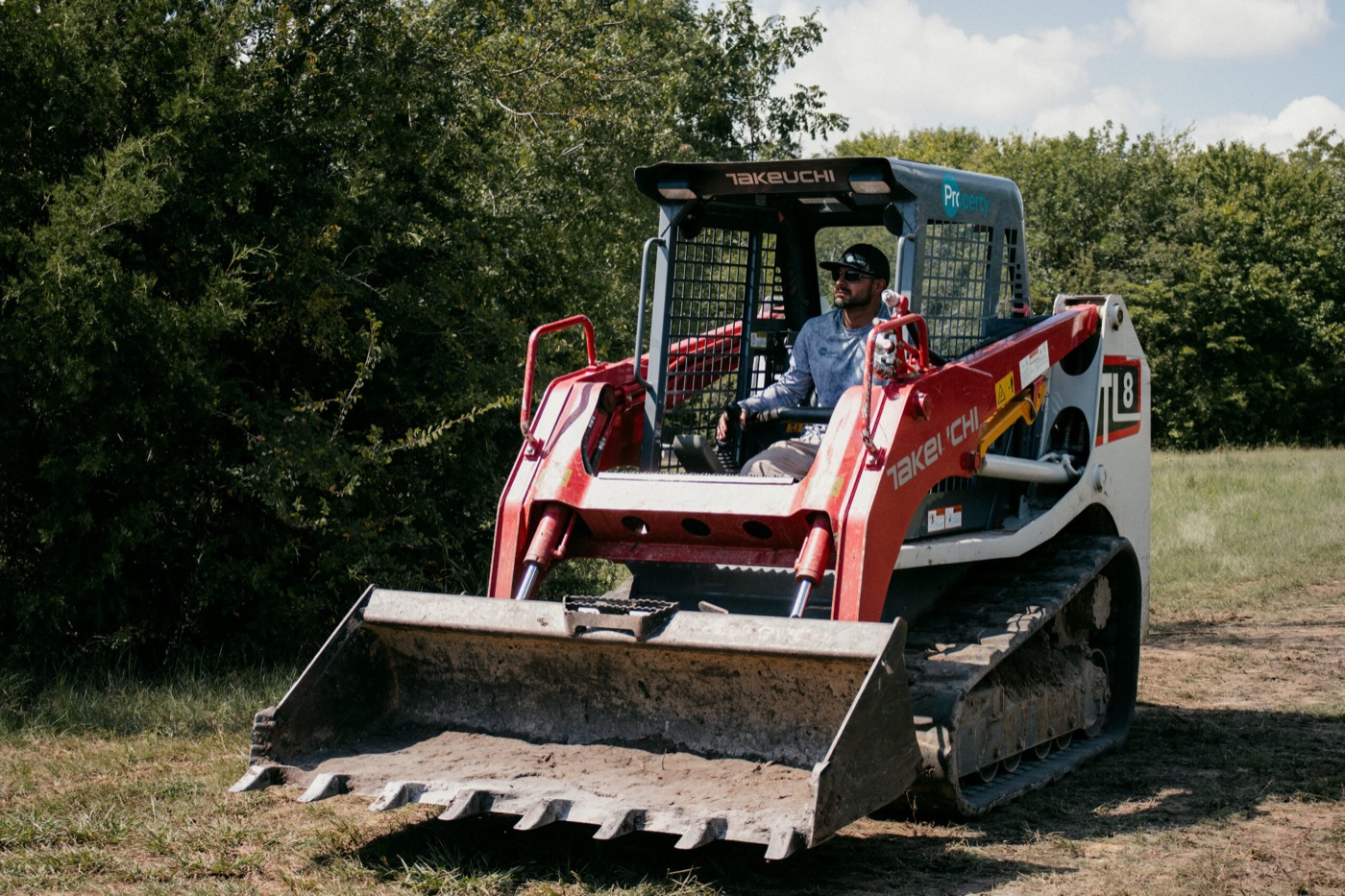 Skid steer performing earthwork and site maintenance